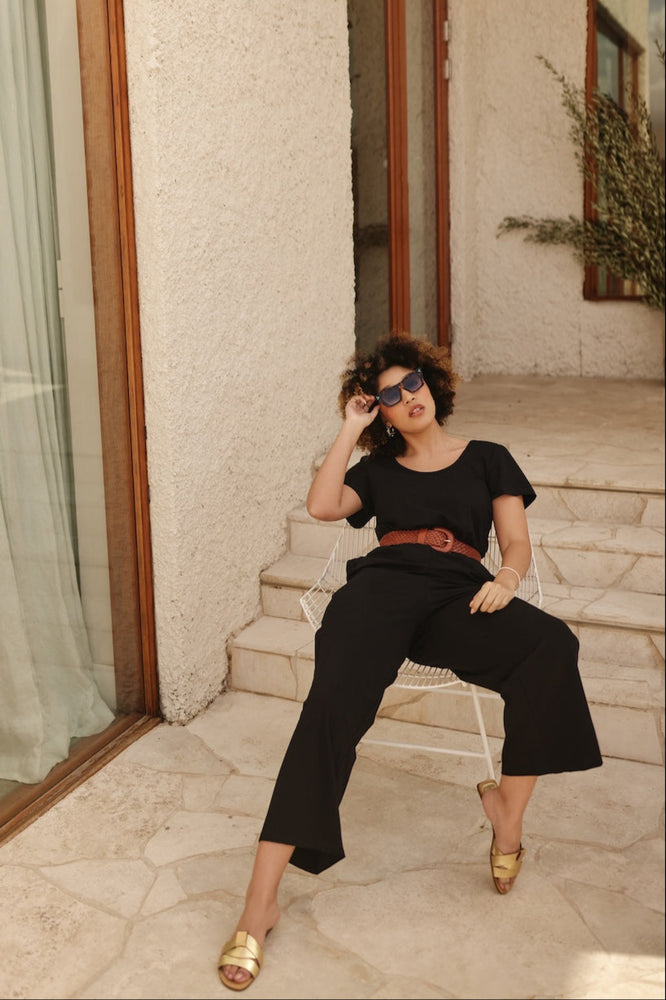 
                      
                        Woman in black outfit sitting on steps outdoors
                      
                    