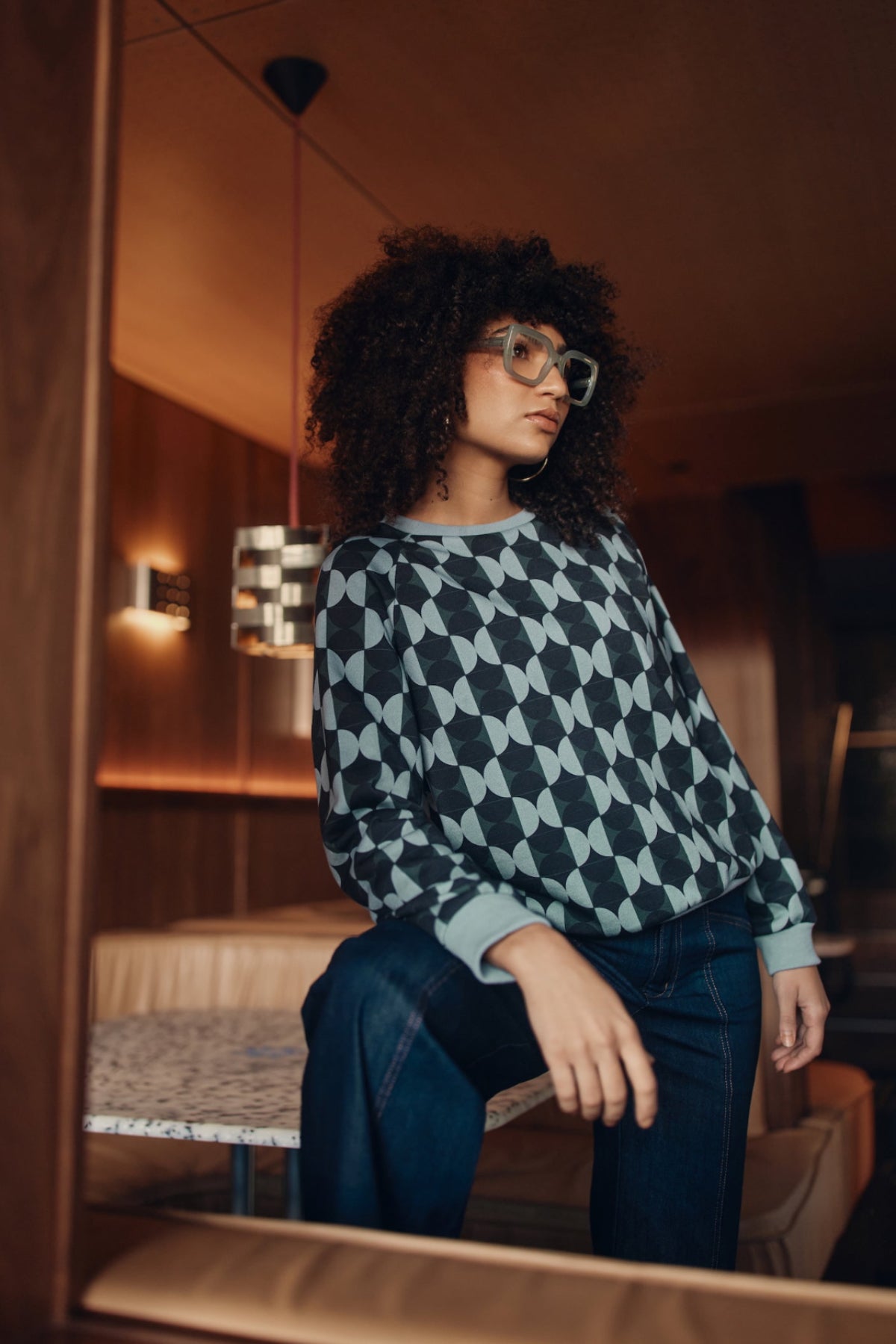Woman wearing a patterned sweater in a cozy indoor setting