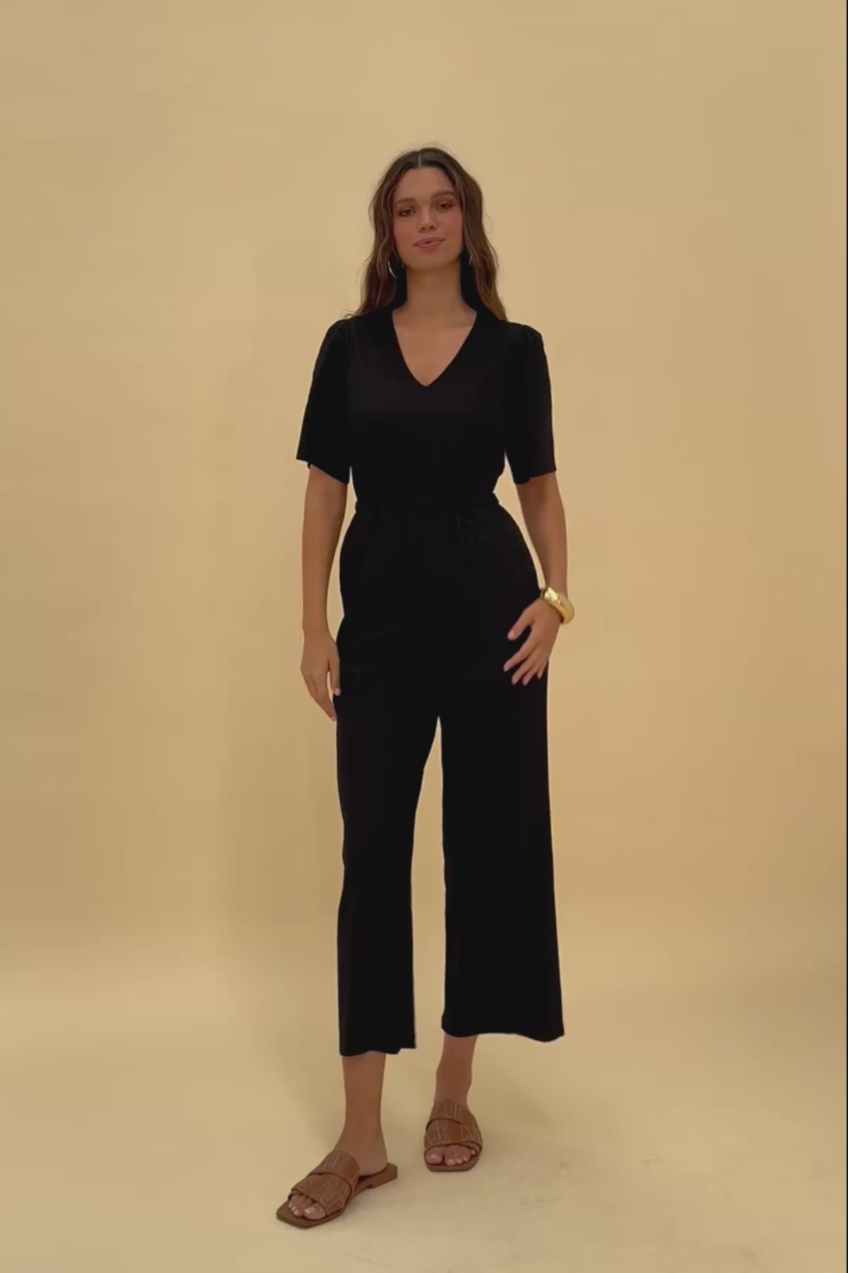 Woman standing wearing Frock Me Out BLACK V Neck Sleevie Wonder Jumpsuit
